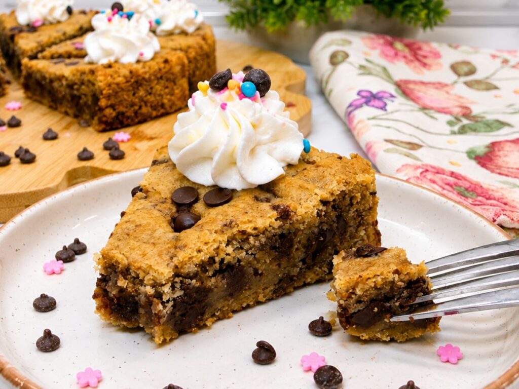 Close-up of a soft and chewy Chocolate Chip Cookie Cake slice filled with dark chocolate chips.