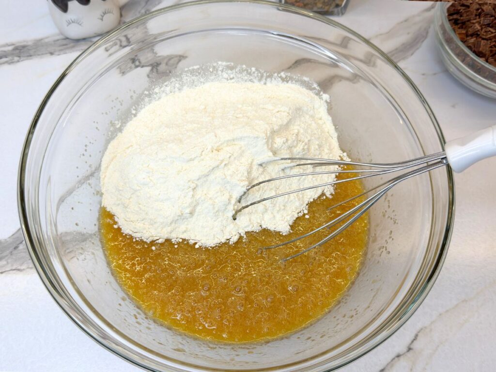 Dry ingredients added to the wet mixture for Chocolate Chip Cookie Cake.