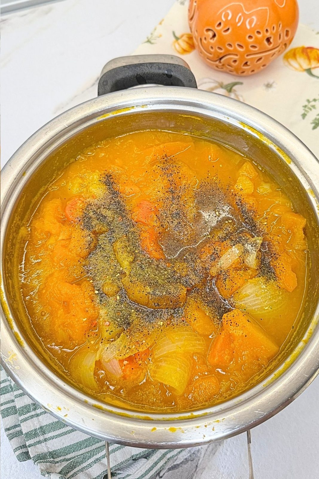 Tender cooked pumpkin and vegetables topped with salt, black pepper, and vegetable seasoning