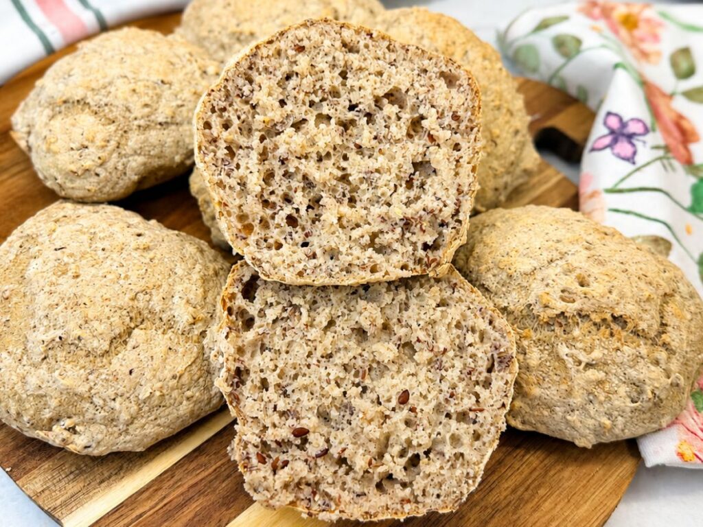 Gluten-Free Multigrain Rolls cut in half to show their soft, airy crumb with ground flaxseed.