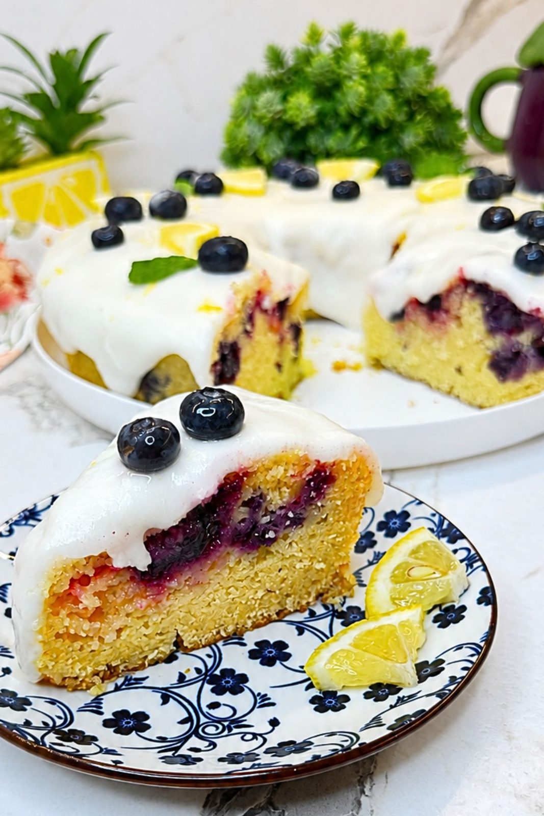 Moist Lemon Blueberry Bundt Cake slice with juicy blueberries and thick lemon icing