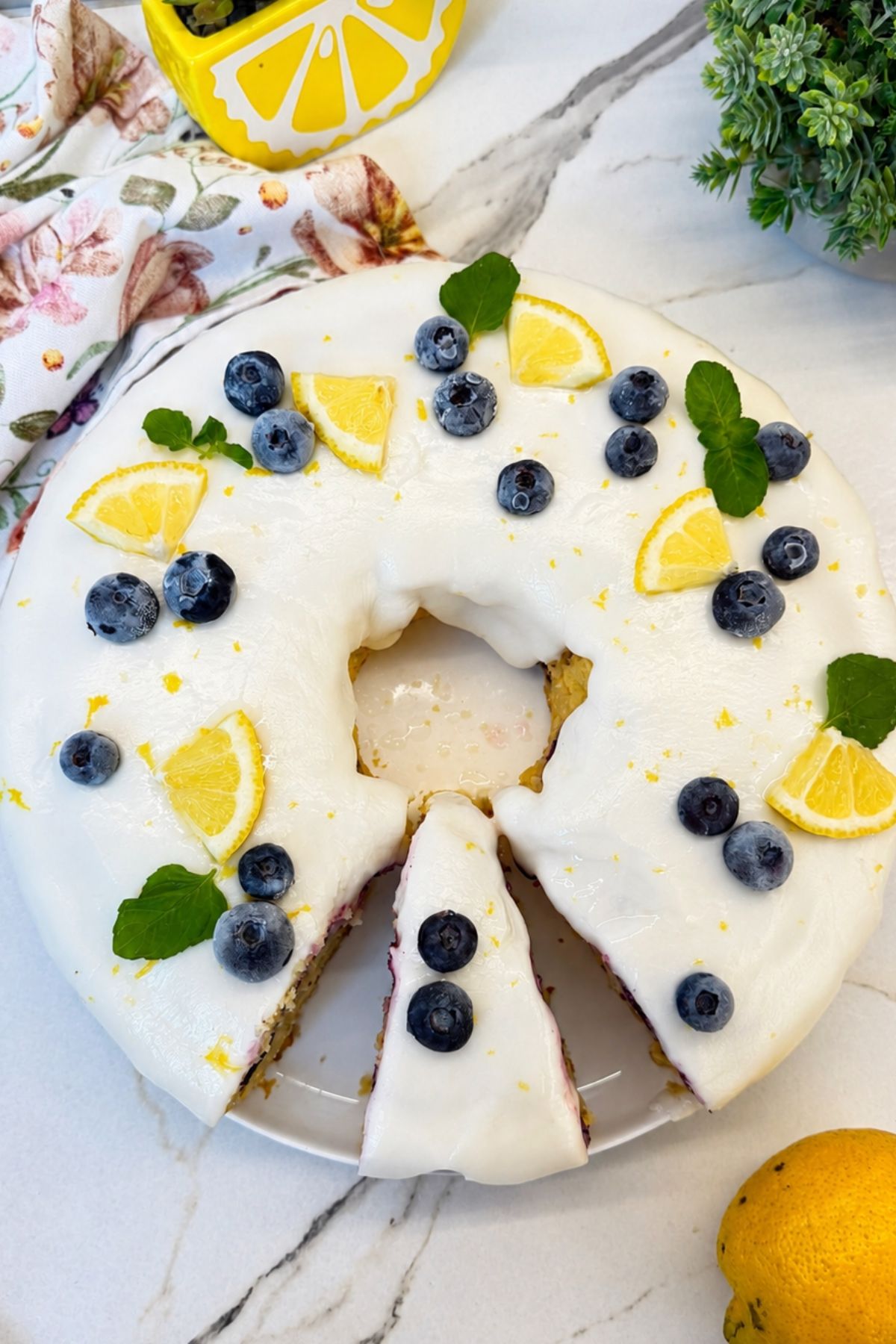 Lemon blueberry Bundt cake with lemon icing, fresh blueberries, and a slice removed