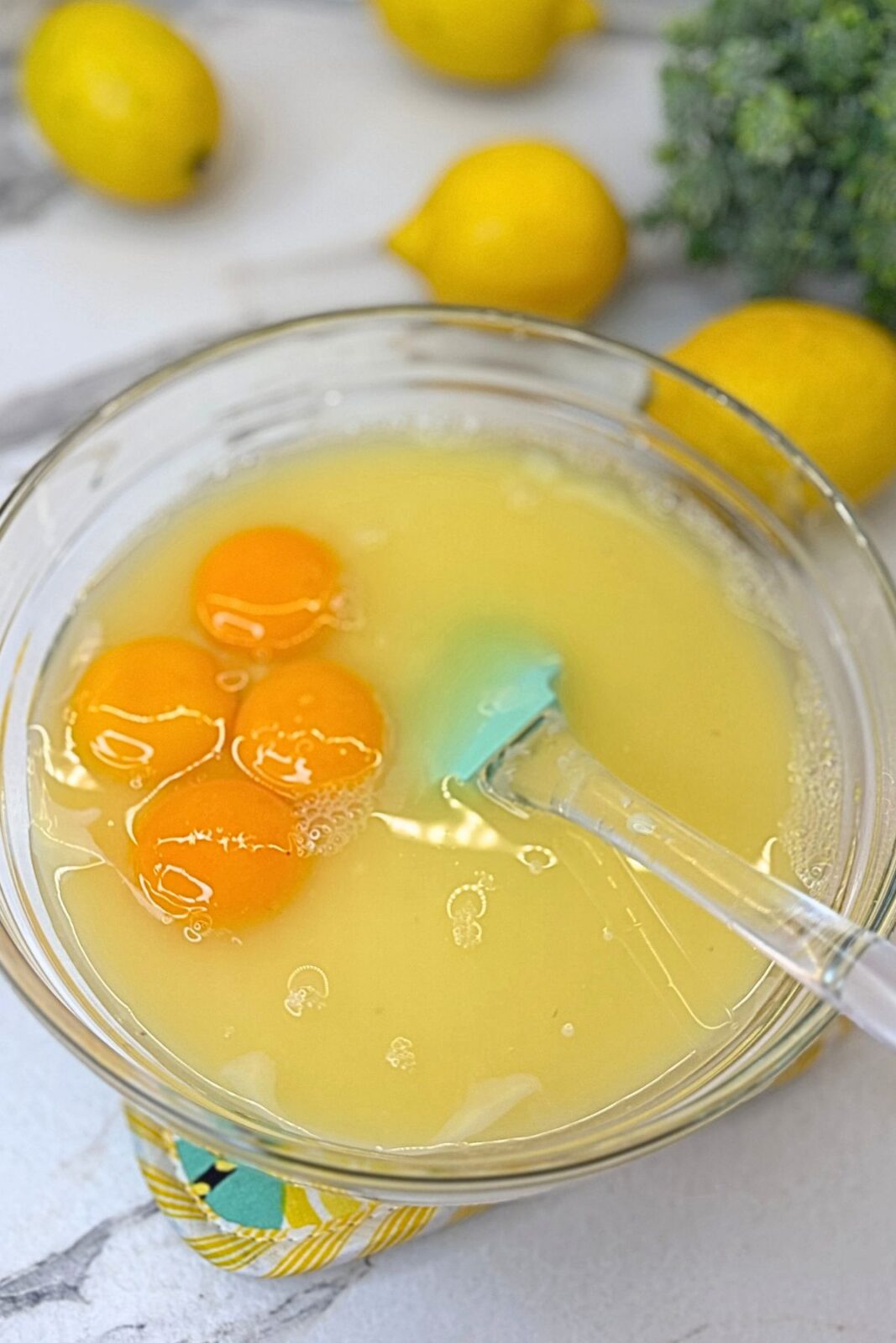 Sweetened condensed milk, fresh lemon juice, and egg yolks in a bowl for the lemon pie filling