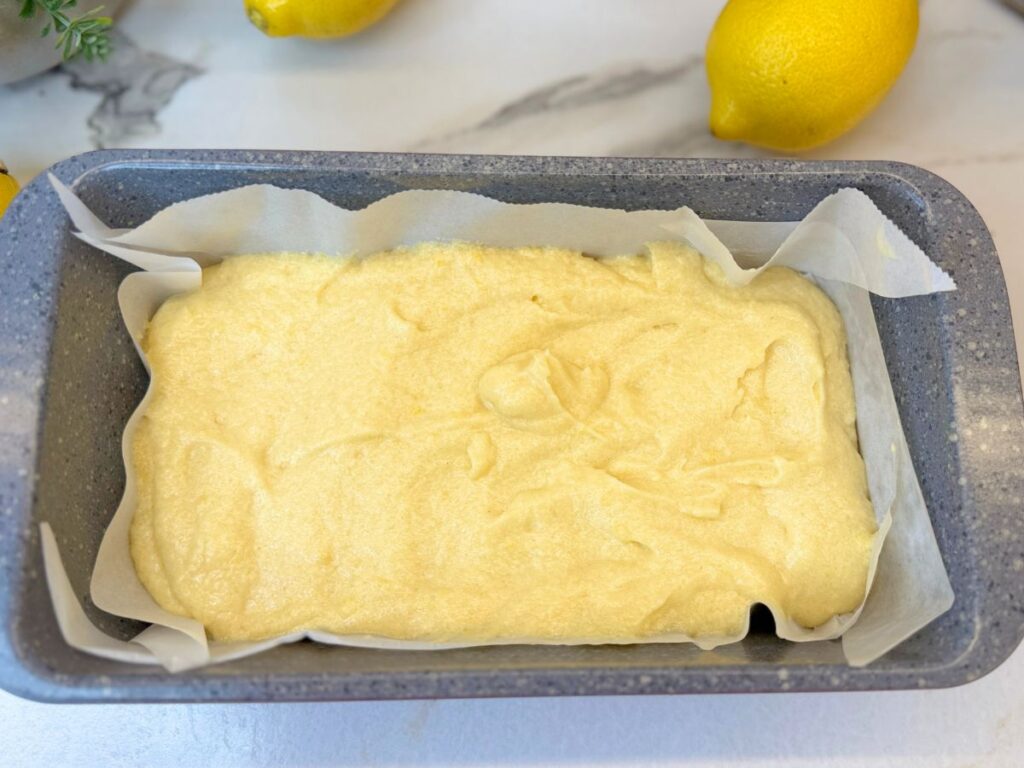 Lemon pound cake batter in a parchment-lined loaf pan