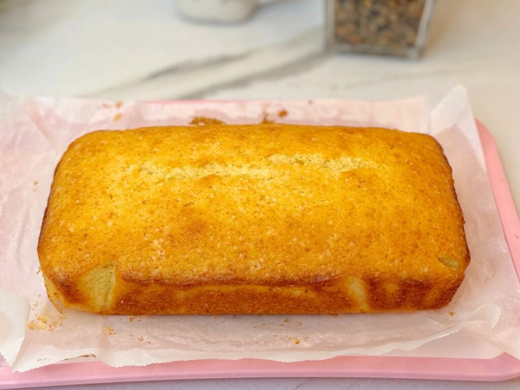 Freshly baked golden lemon pound cake cooling on parchment paper
