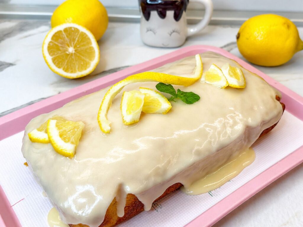 Glazed lemon pound cake decorated with fresh lemon slices and mint