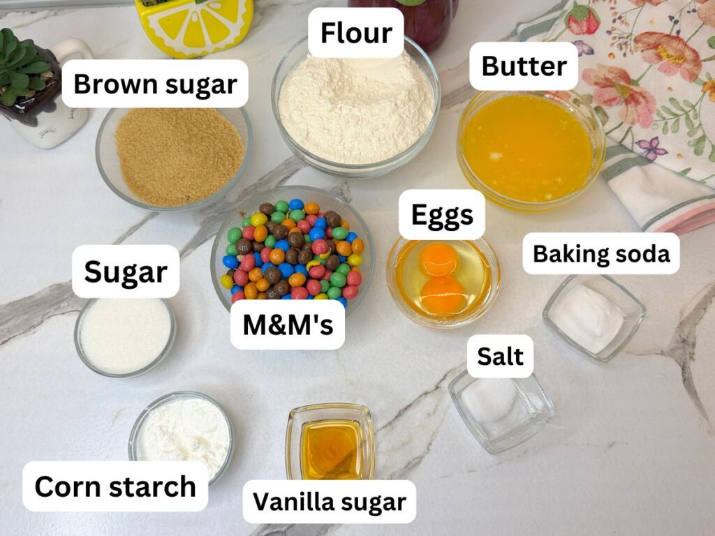 Ingredients for soft and chewy M&M cookies arranged on a table.
