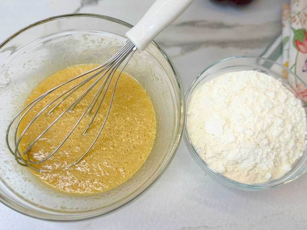 Dry and wet ingredients for M&M cookies prepared in separate mixing bowls.