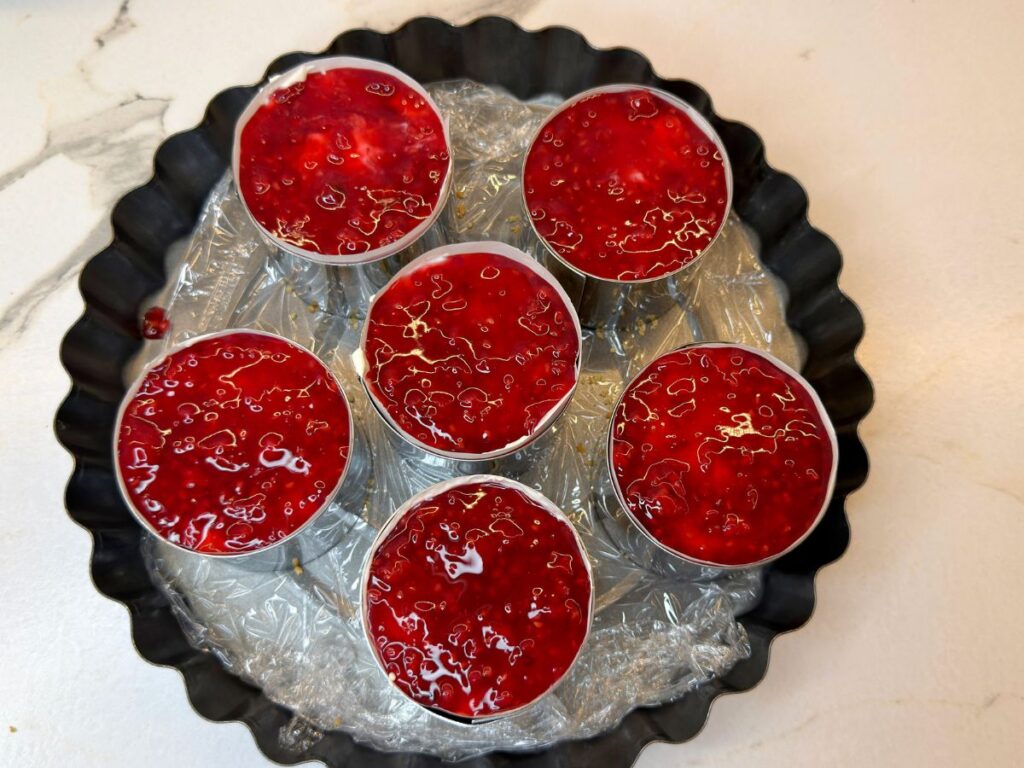 Plain cheesecake filling divided among six prepared mini dessert molds.