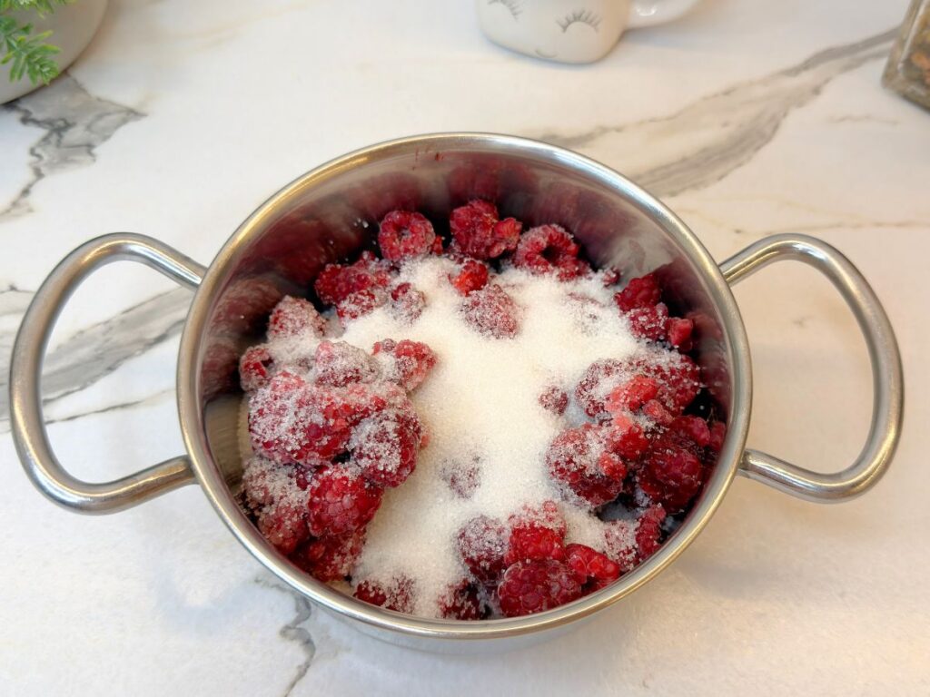 Mixed berries and granulated sugar in a saucepan ready to be cooked.