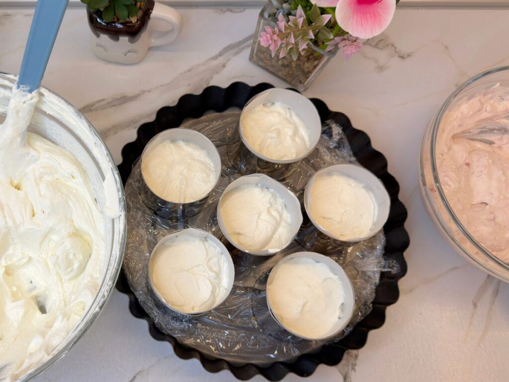 Plain cheesecake filling divided among six prepared mini dessert molds.