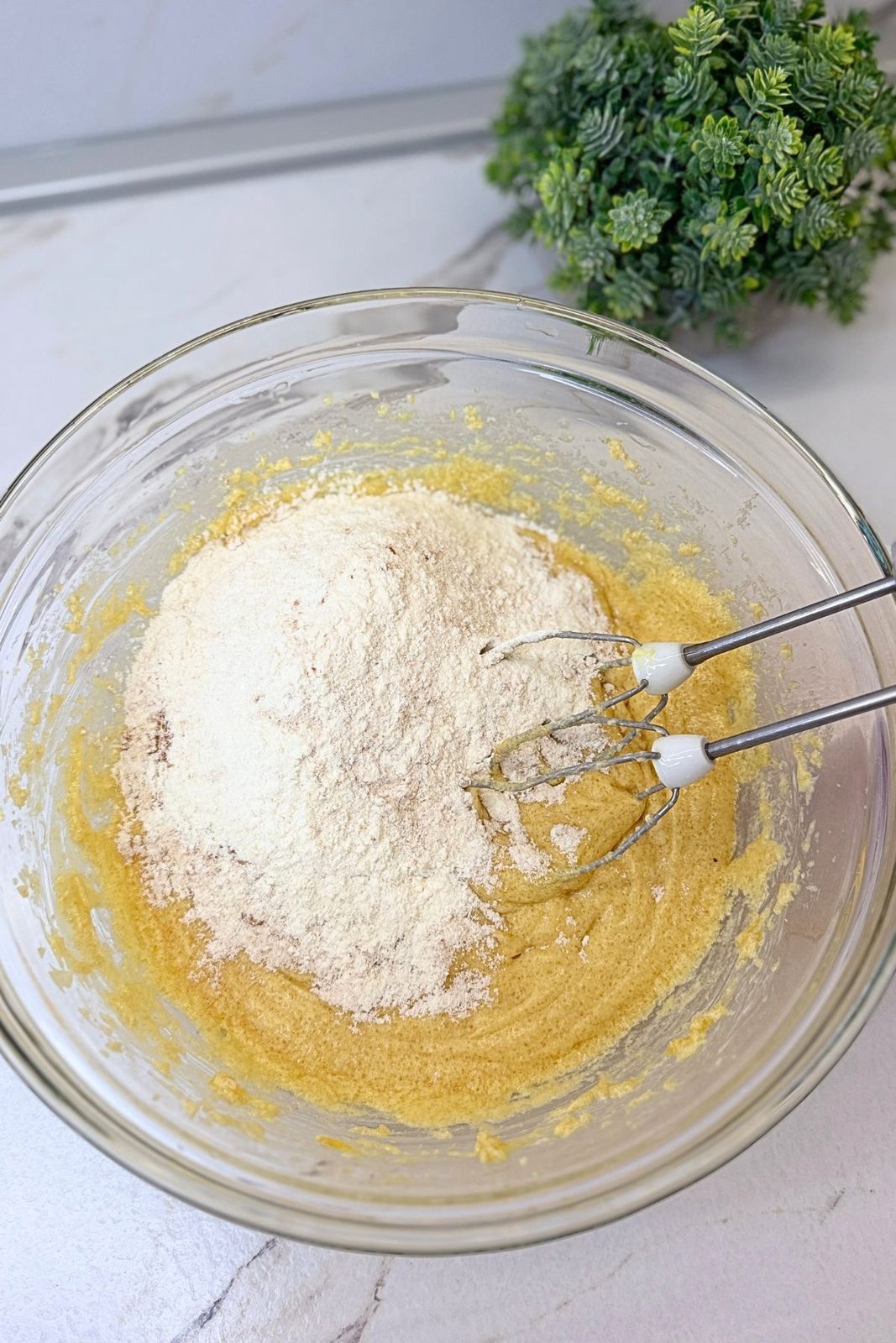 Dry ingredients being added to the wet oatmeal cookie mixture