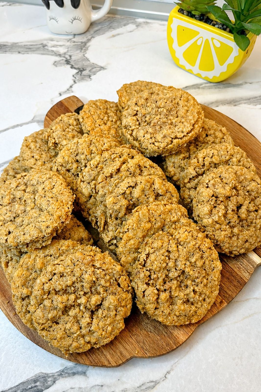 Freshly baked oatmeal cookies cooling on a wooden serving board