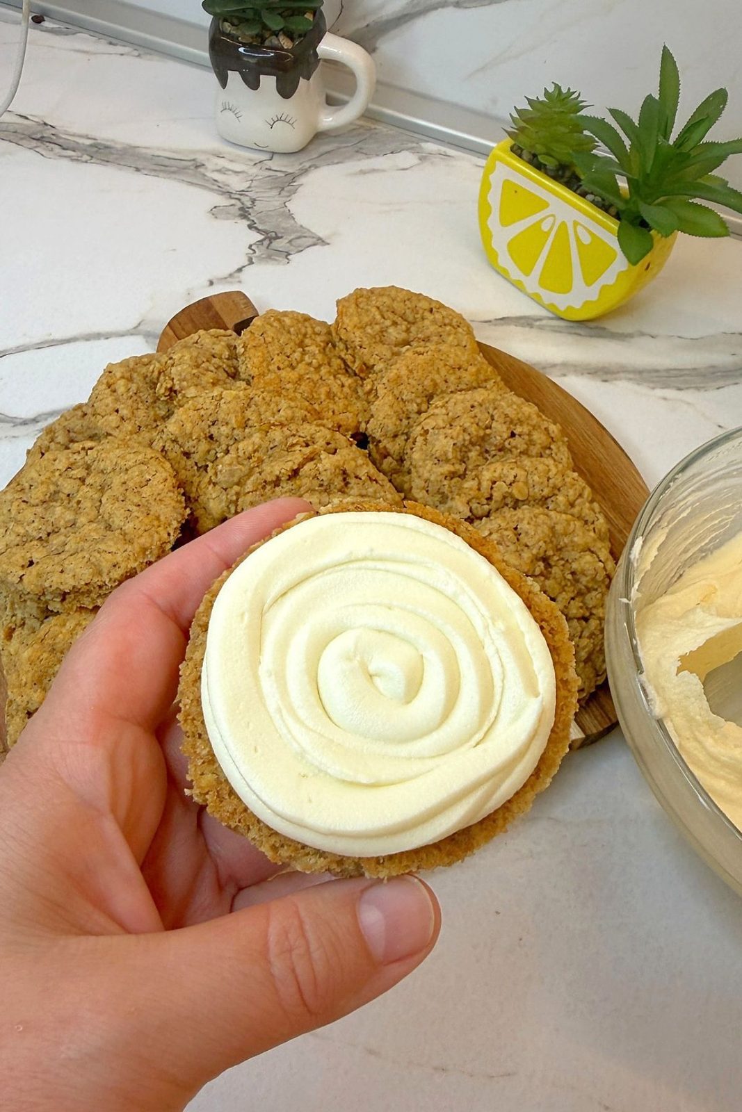 Vanilla cream filling piped onto a cooled oatmeal cookie