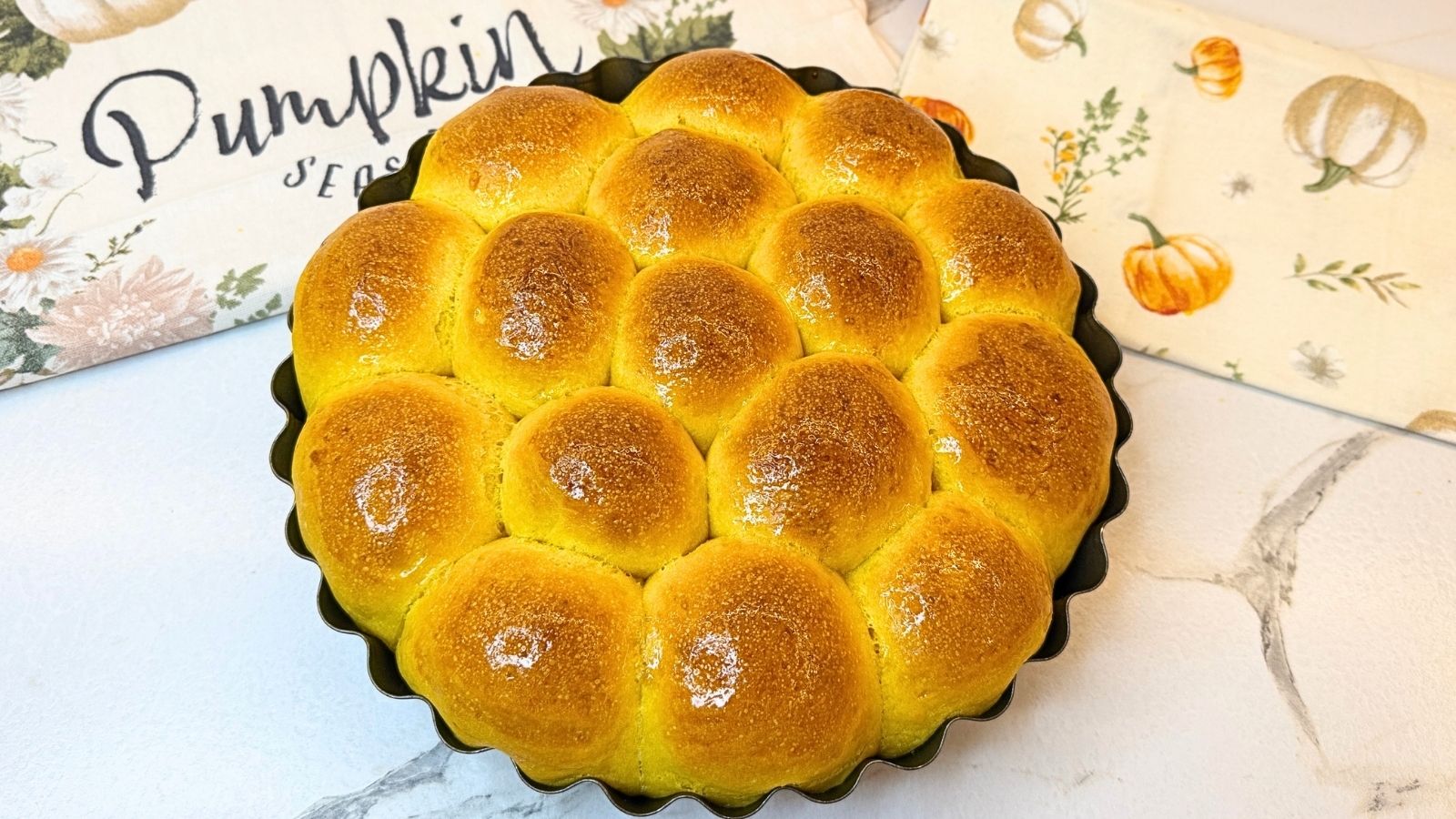 Soft and fluffy Pumpkin Dinner Rolls baked until golden brown in a round pan