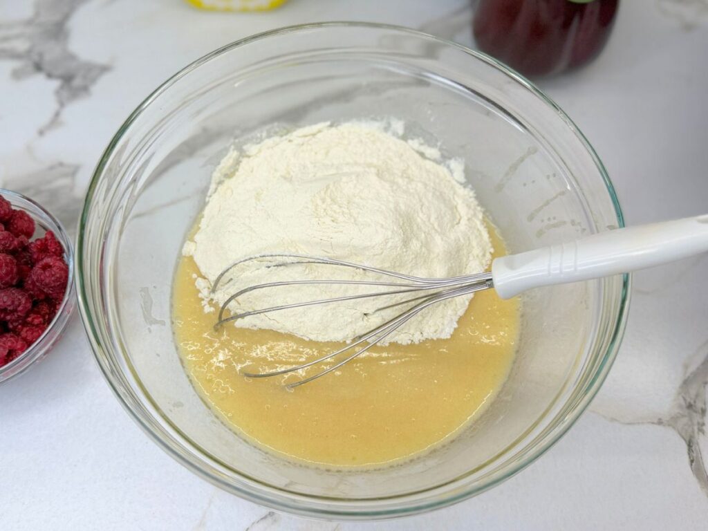 Wet ingredients poured into the dry ingredients to make raspberry bread batter.