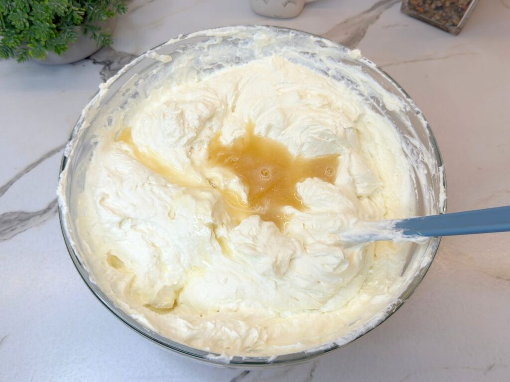 Melted gelatin being mixed into the cream cheese filling for No-Bake Raspberry Cheesecake