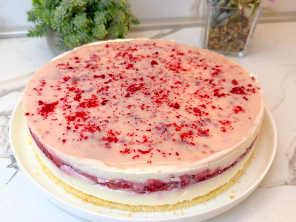 Chilled raspberry cheesecake removed from the cake ring before final decoration