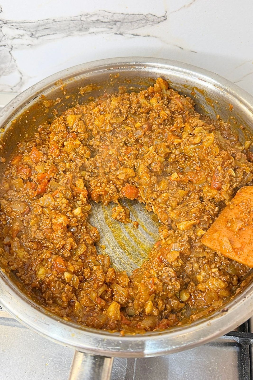 Seasoned ground beef and tomato filling cooked in a skillet for zucchini boats.