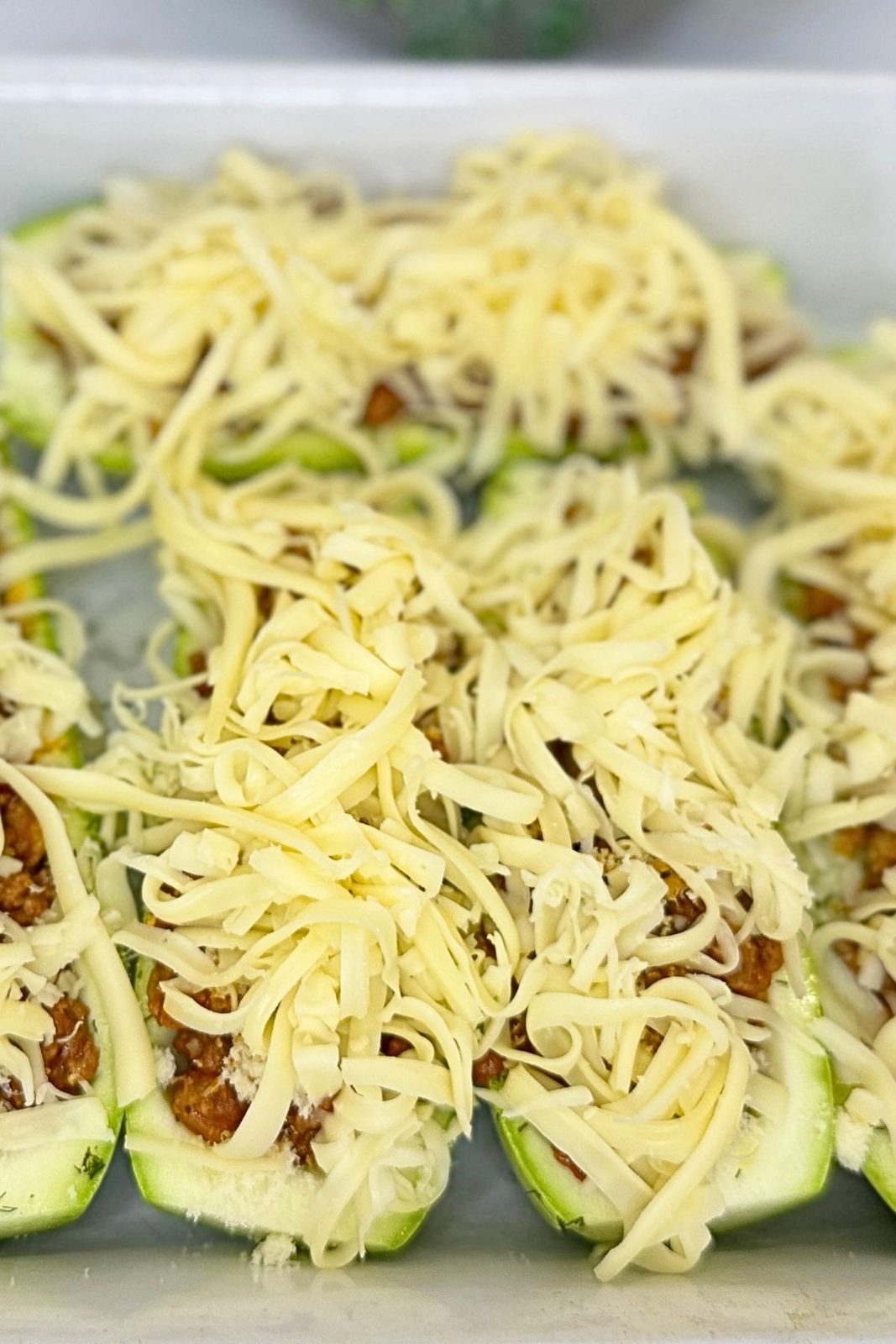 Hollowed zucchini boats filled with a seasoned ground beef and vegetable mixture.