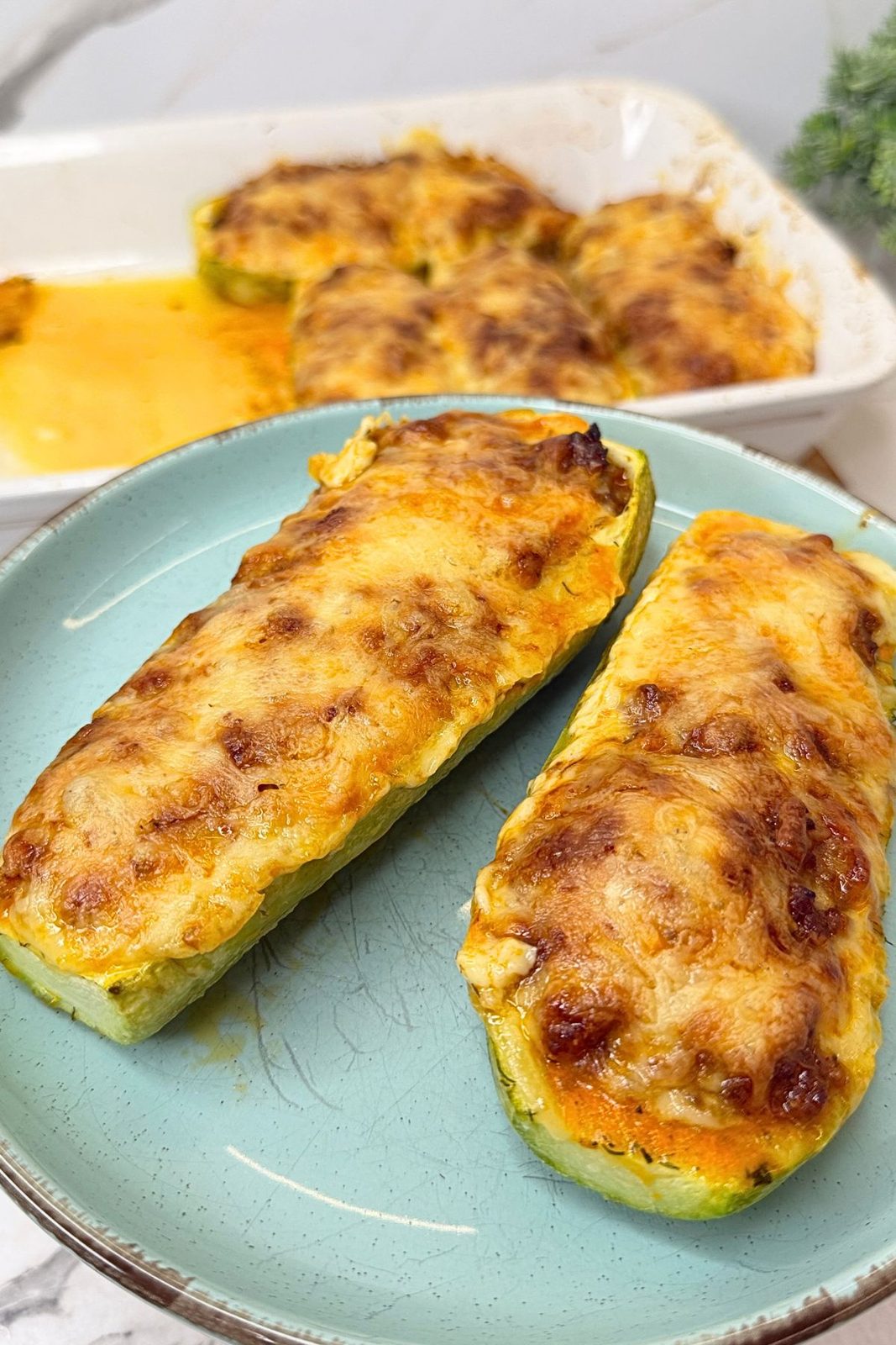 Close-up of zucchini boats filled with seasoned ground beef and topped with golden melted cheese.