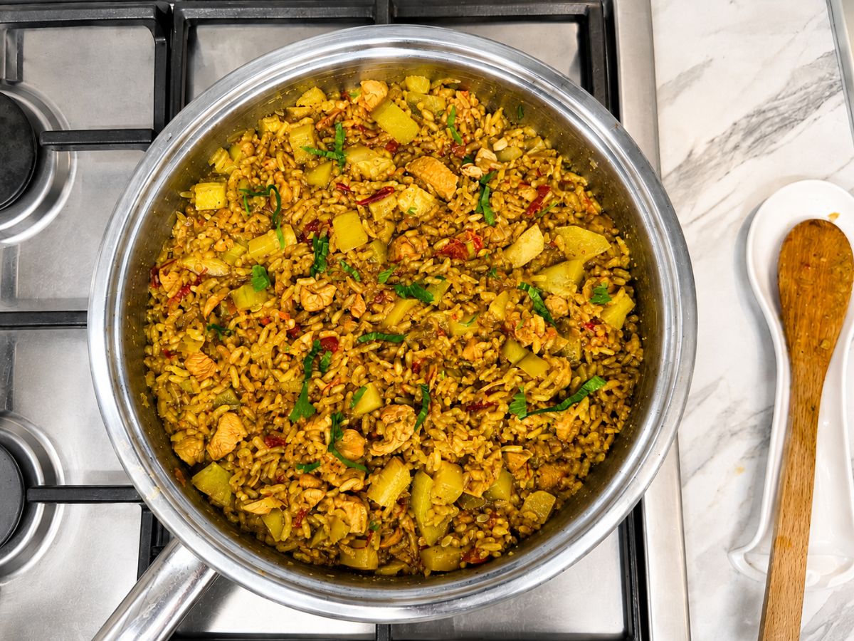 One-pot chicken and rice with vegetables served in a large ceramic bowl on a family-style dinner table.