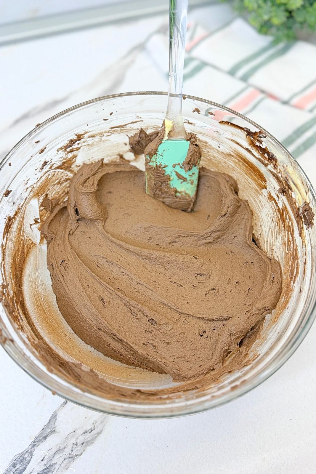Smooth and creamy homemade chocolate buttercream prepared for frosting the cake