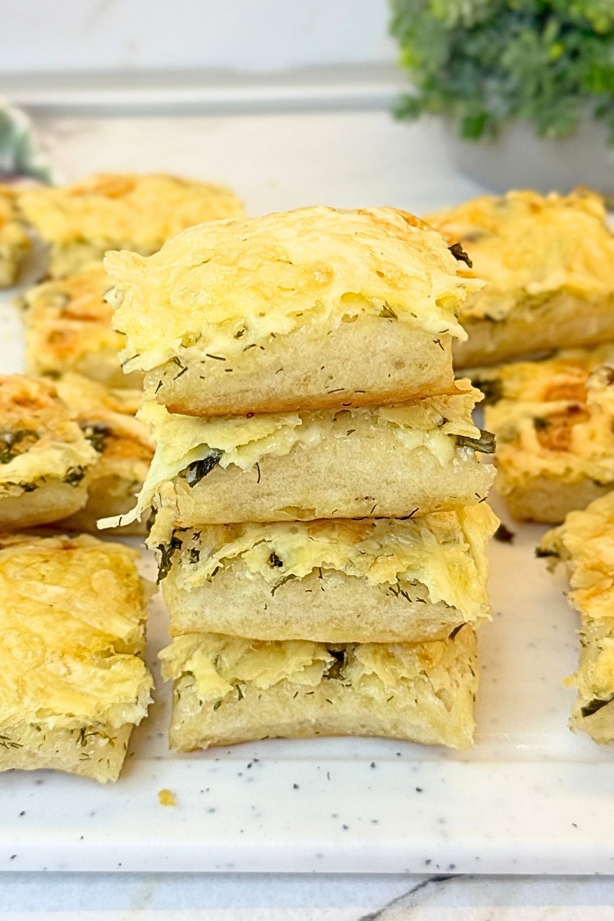 Homemade garlic bread topped with melted cheese and fresh herbs