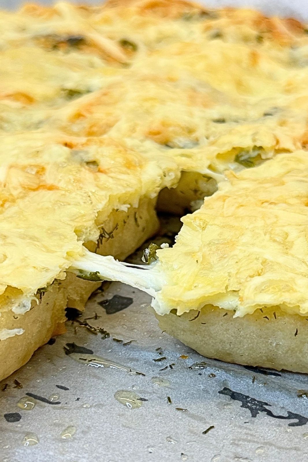 Pulling apart warm garlic bread squares with melted cheese