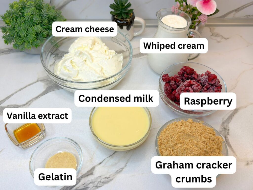 Ingredients for no-bake mini cheesecakes arranged on a marble countertop.