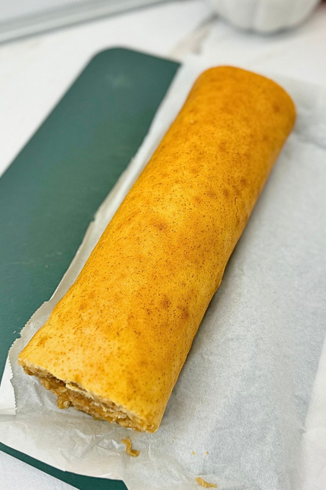 Unwrapped apple cinnamon cake roll before dusting with powdered sugar.