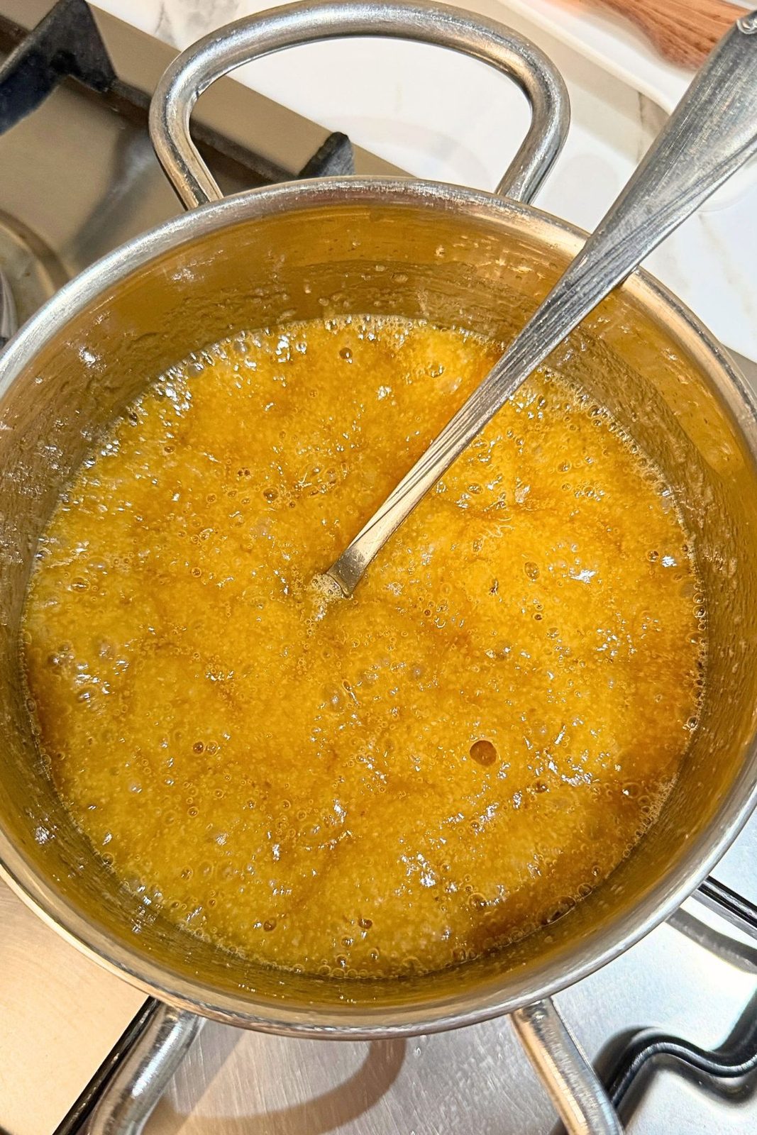 Butter and brown sugar bubbling in a saucepan for the apple upside down cake topping.