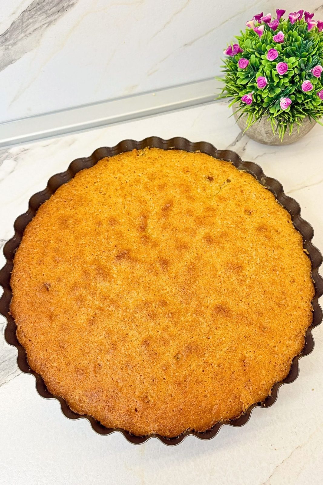 Golden-brown apple upside down cake in its baking pan before inverting.