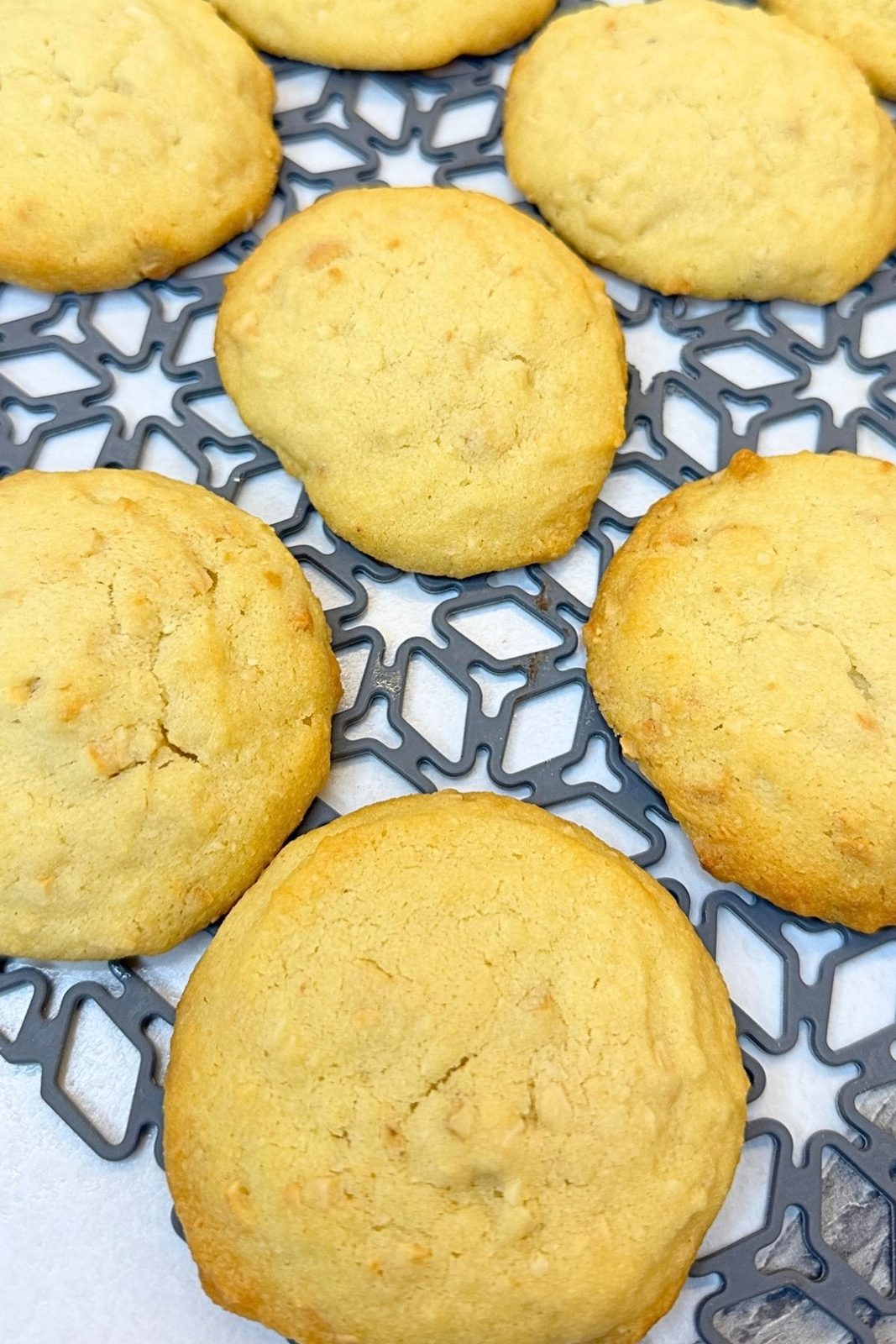 Freshly baked cashew cookies cooling on a wire rack before coating