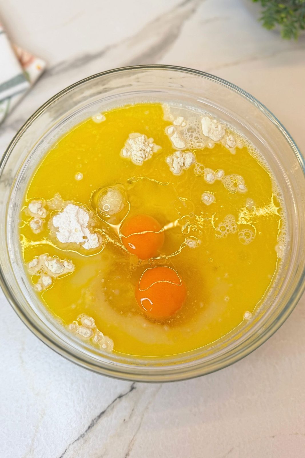 Flour, eggs, milk, water, melted butter, oil, sugar, and vanilla added to a mixing bowl
