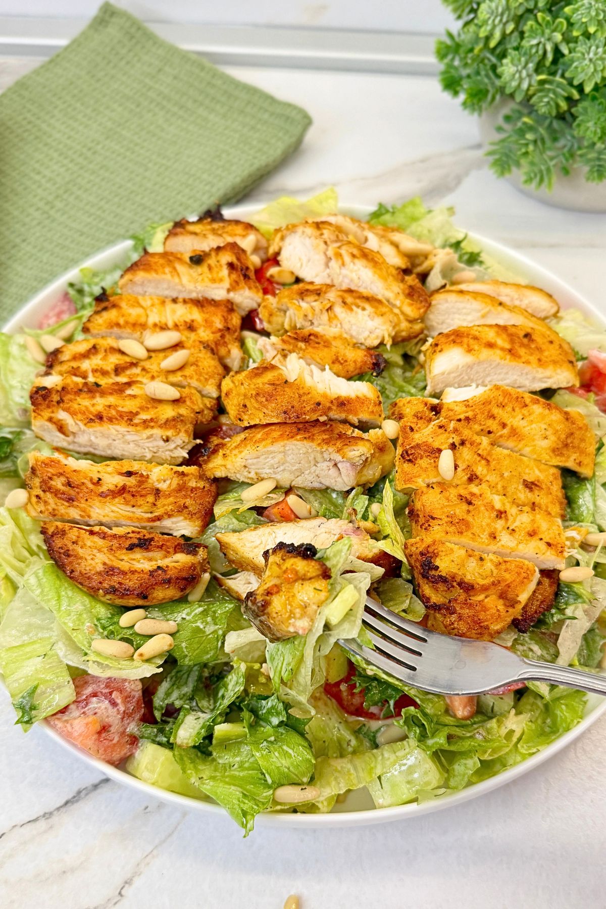 Easy grilled chicken salad with creamy dressing, fresh vegetables, and toasted pine nuts.