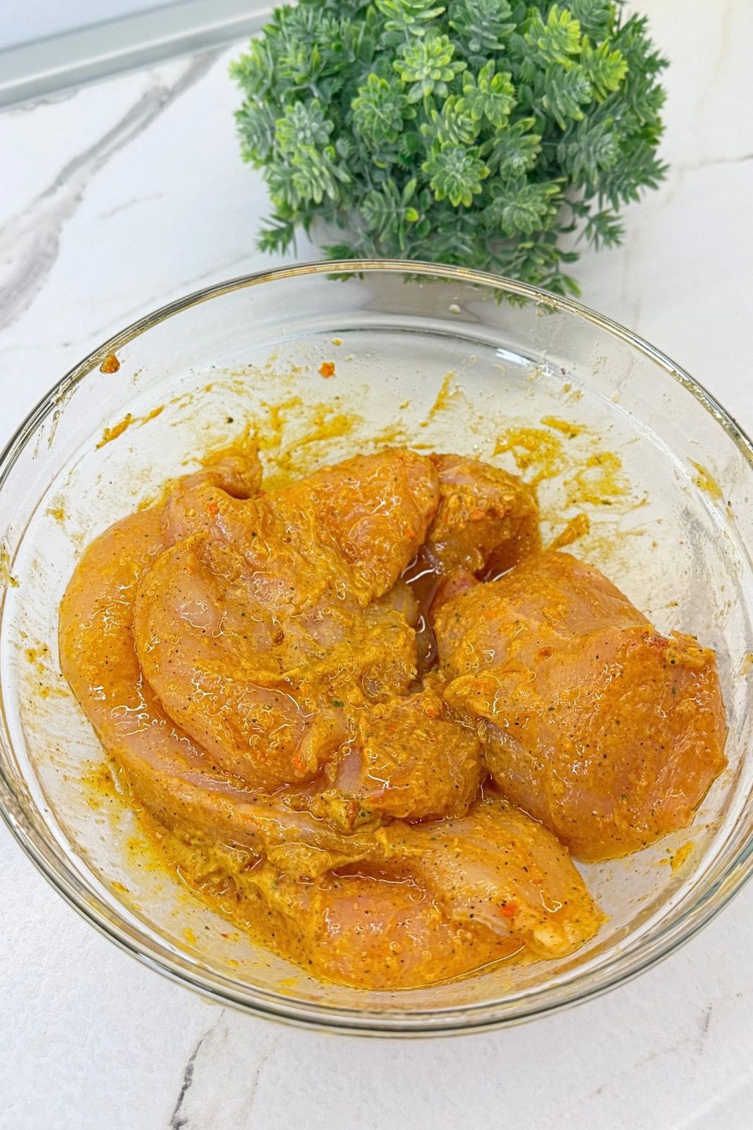 Chicken breast cutlets coated with mustard, salt, black pepper, and seasonings.