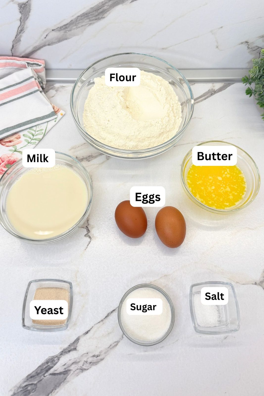 Labeled ingredients for glazed donut dough: flour, milk, melted butter, eggs, yeast, sugar, and salt.