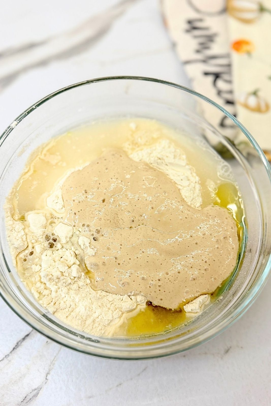 Activated yeast, flour, olive oil, and warm water ready for making homemade pizza dough