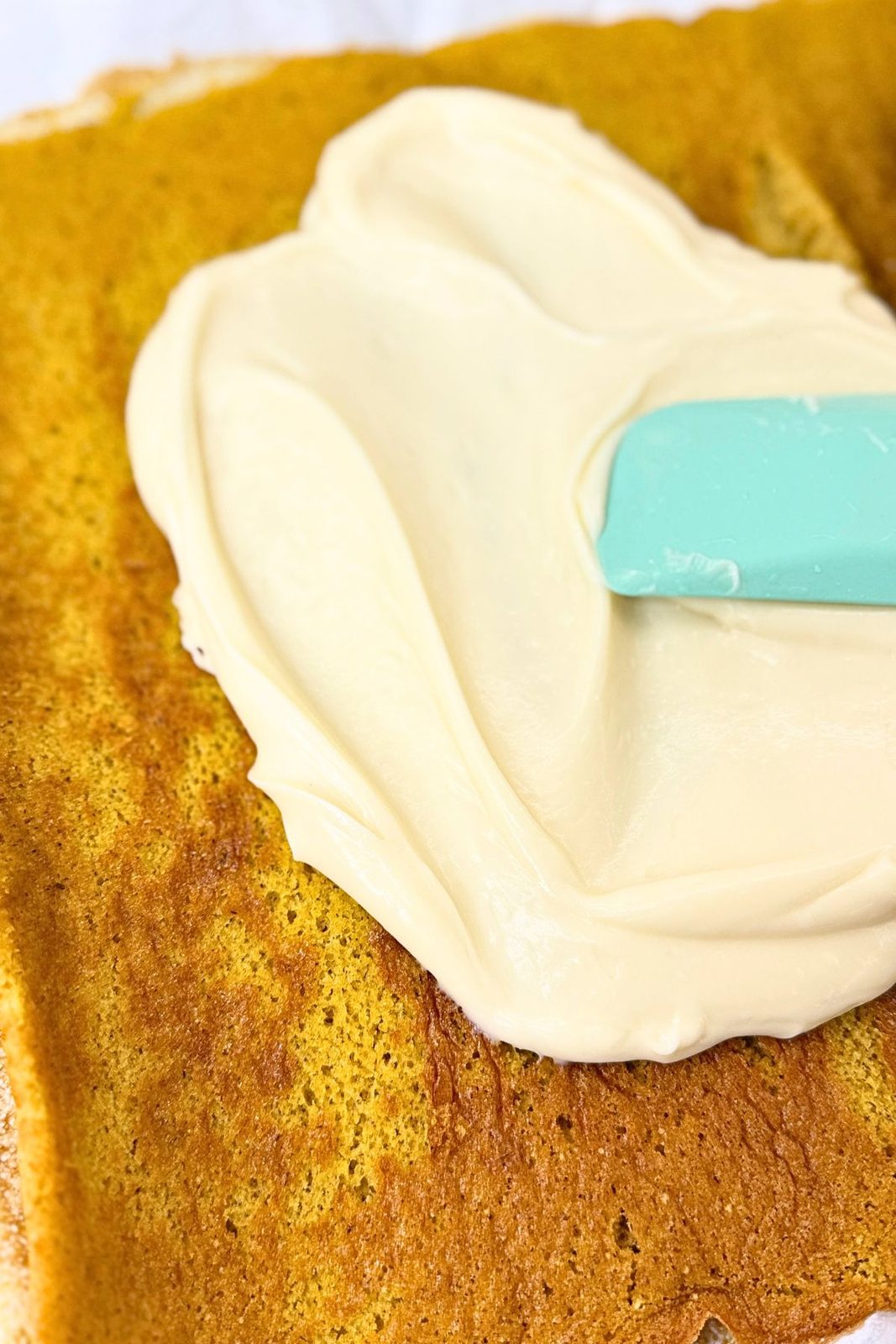 Cream cheese filling spread over the unrolled pumpkin sponge.