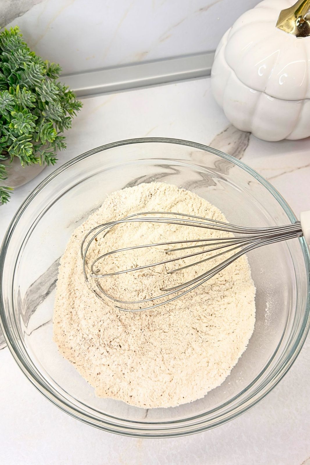 Dry ingredients for pumpkin cake roll combined in a mixing bowl.