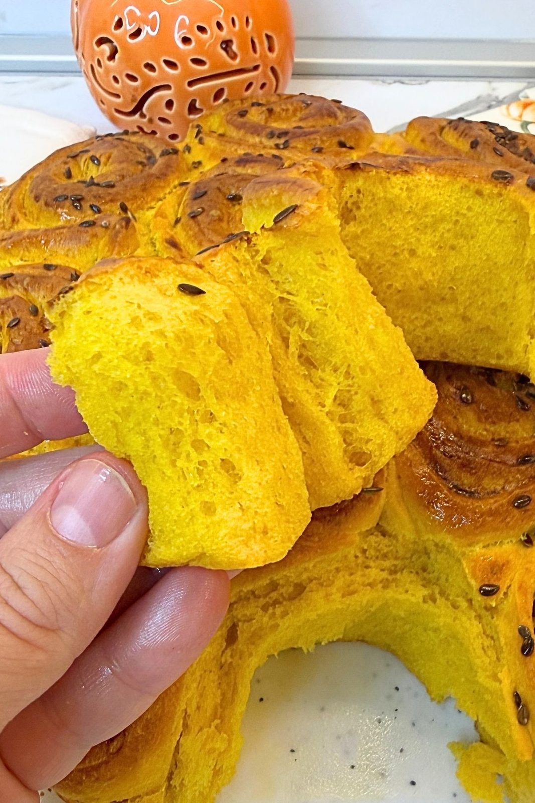 Soft and fluffy interior of Swirled Pumpkin Dinner Rolls being pulled apart by hand