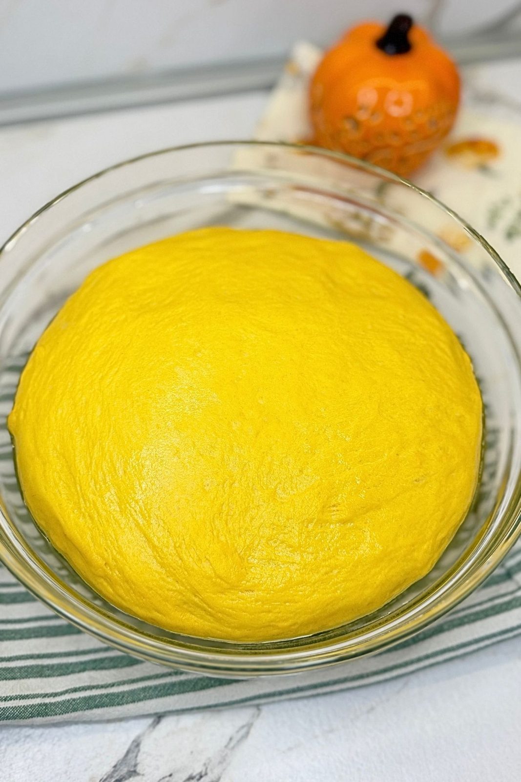 Soft pumpkin dough doubled in size after the first rise