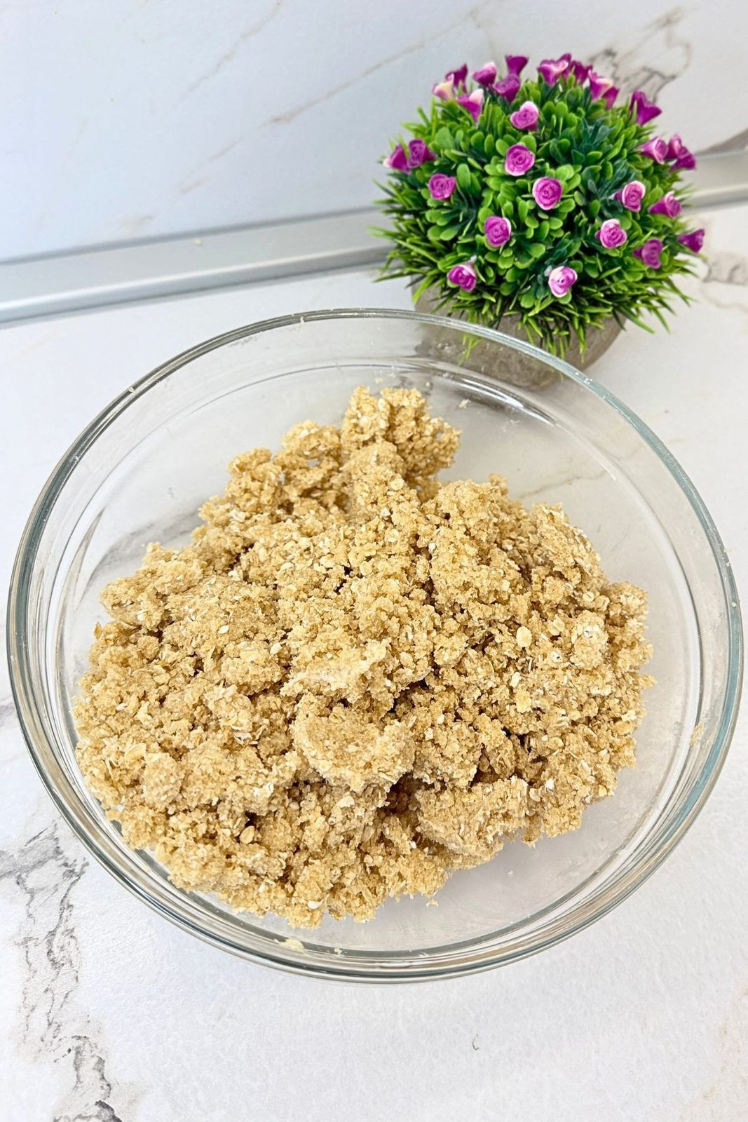Crumbly apple crisp topping with oats, brown sugar, flour, and butter mixed into small clusters.