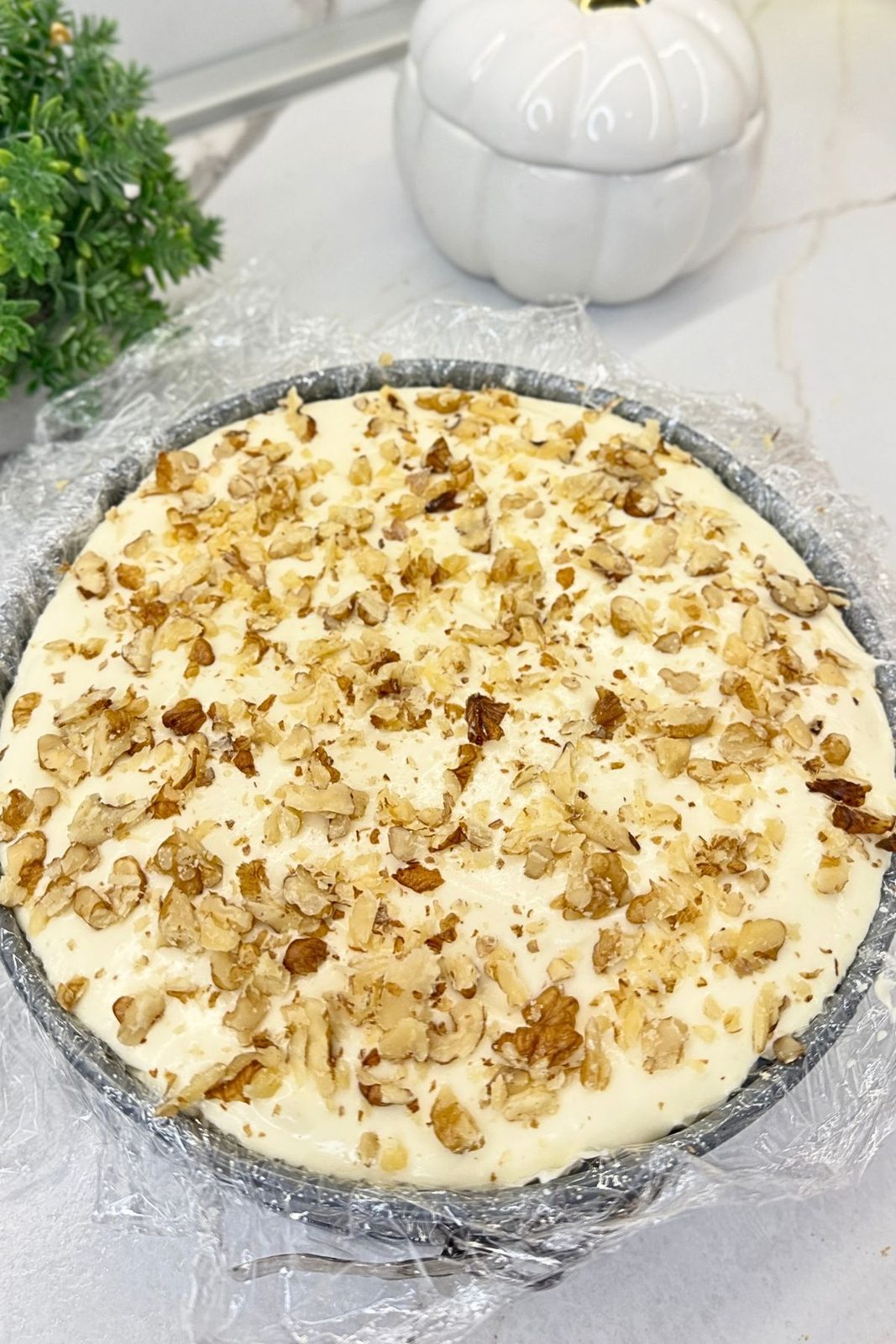 Assembled carrot cake topped with a smooth layer of cream cheese frosting.