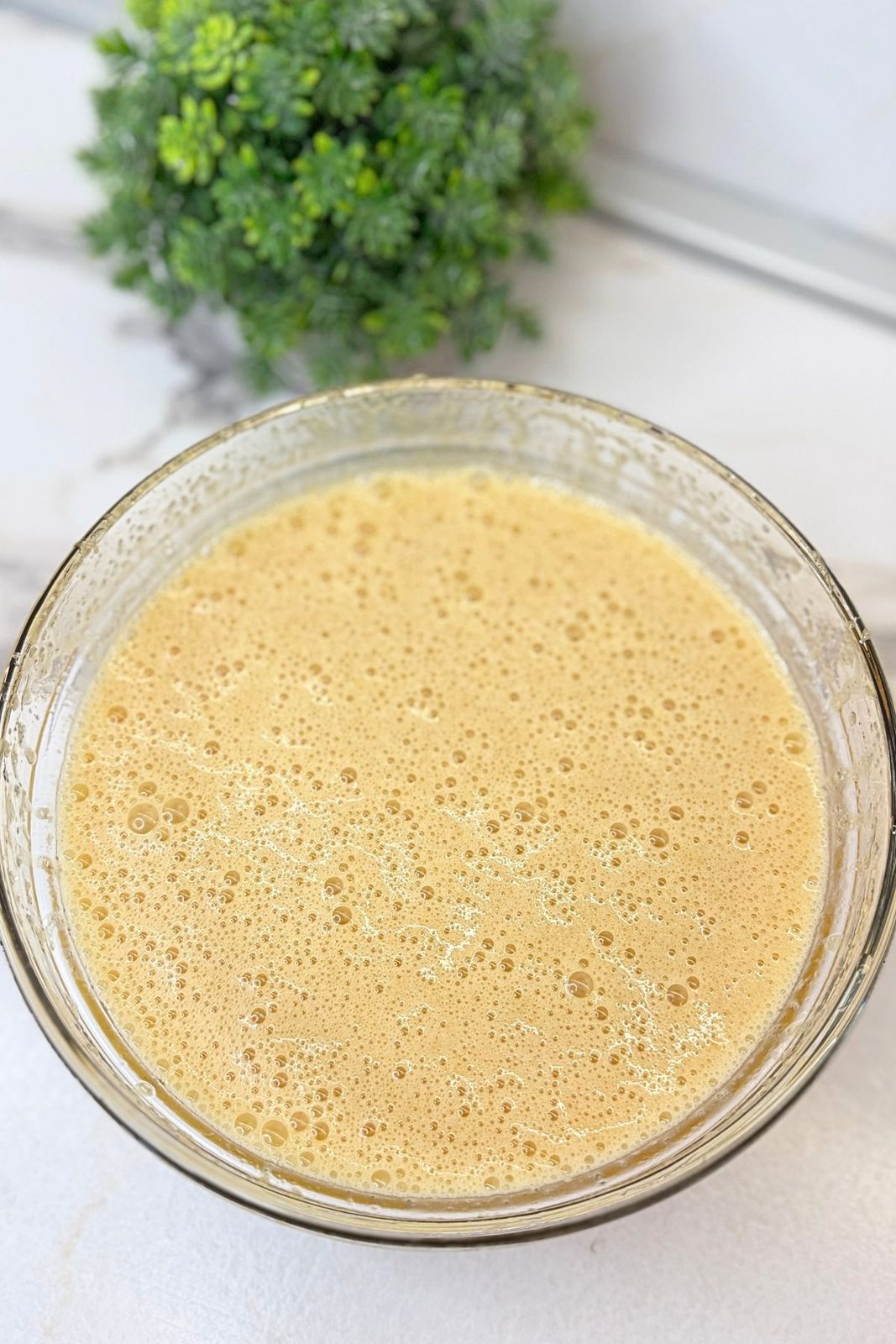 Carrot cake wet ingredients beaten together in a glass mixing bowl.