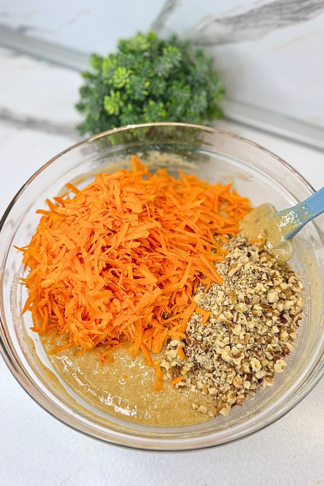 Grated carrots and chopped walnuts added to carrot cake batter before folding.