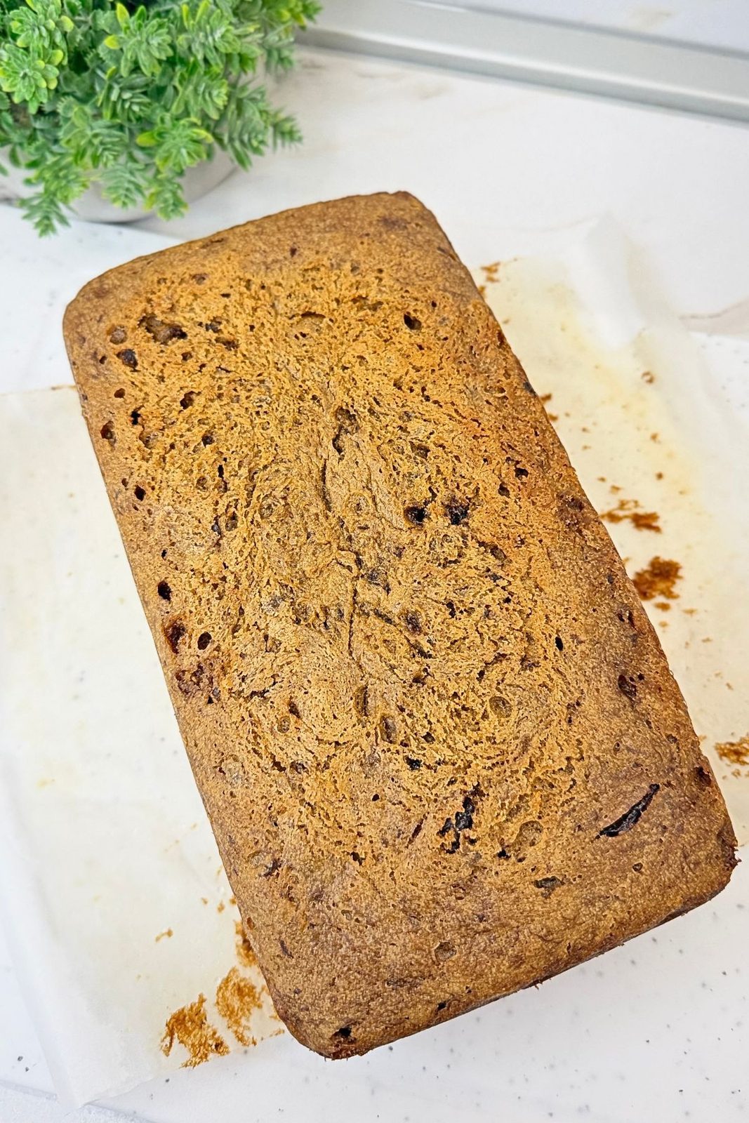 Baked chocolate chip banana bread with a golden-brown top, removed from the loaf pan.
