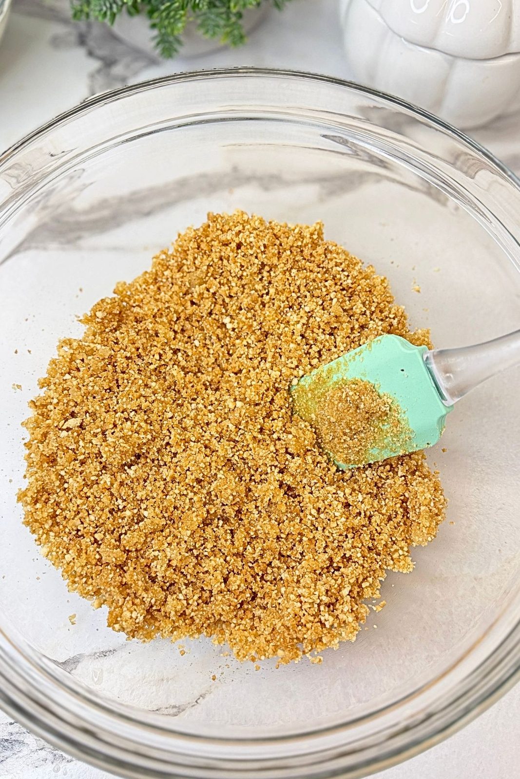 Graham cracker crumbs mixed with melted butter and sugar for the pumpkin cheesecake crust.