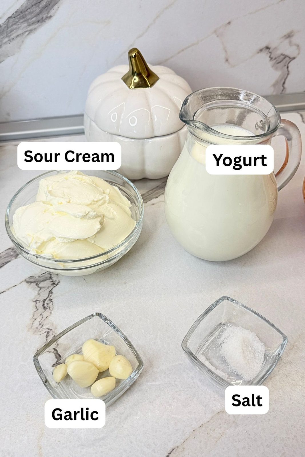 Garlic yogurt sauce ingredients: plain yogurt, sour cream, fresh garlic cloves, and salt.